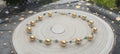 Gargantilla Oro de Oriente sobre madera natural con fondo de estrellas