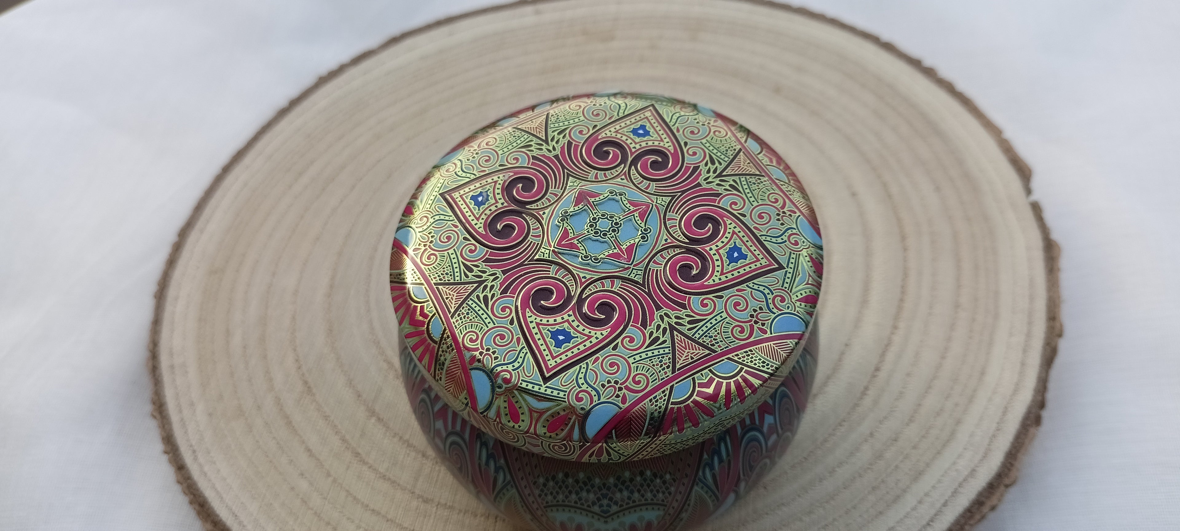 Vela Mandala Eucalipto cerrada sobre rodaja de madera